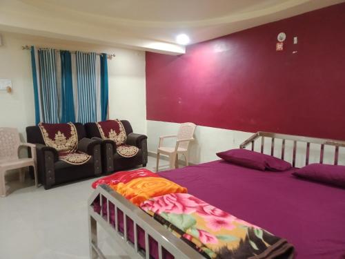 - une chambre avec un lit et des chaises dans l'établissement Hotel KC INN, à Wardha