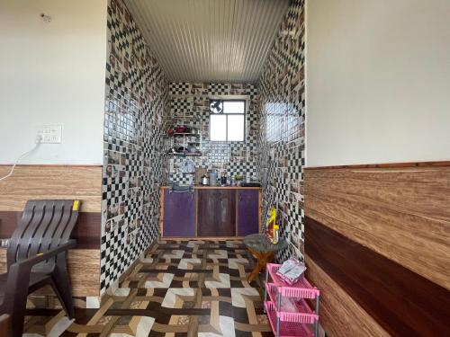 a room with a kitchen with a table and a chair at BirAlive Cafe & Homes in Bīr