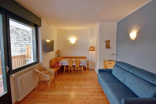 a living room with a blue couch and a table at SISSI Apartment in Madonna di Campiglio