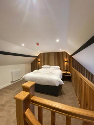 a bedroom with a large bed and a wooden wall at Ramsey Rooms in Huntingdon