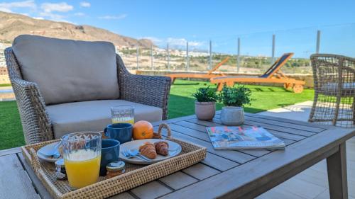 ein Tablett mit Frühstücksspeisen auf einem Tisch auf einer Terrasse in der Unterkunft PANORAMIC pool & mountains house in Finestrat