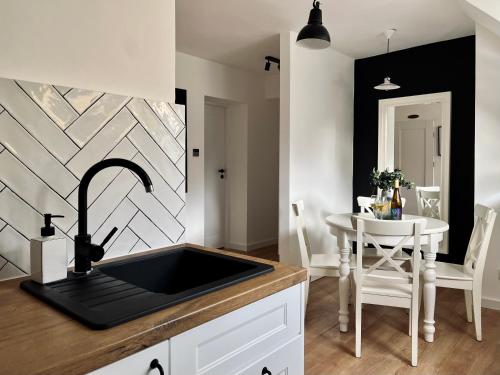 a kitchen with a sink and a table at Apartament Dana Browna in Jelenia Góra