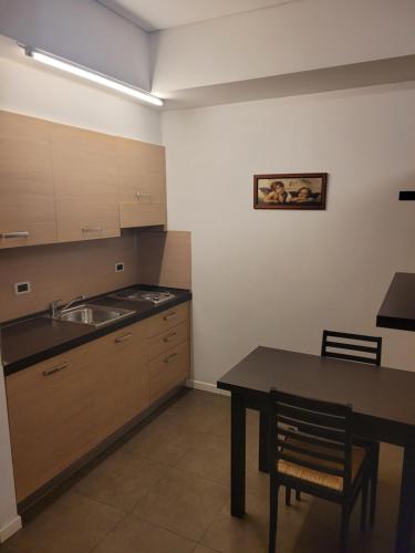 a kitchen with a table and a sink at AFFITTACAMERE GENIUS in Bondeno