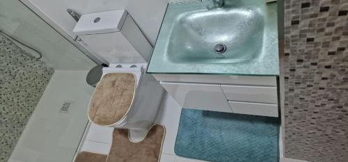 La salle de bains est pourvue d'un lavabo et de toilettes. dans l'établissement SUITES-HOME, CIDADELA, à Praia