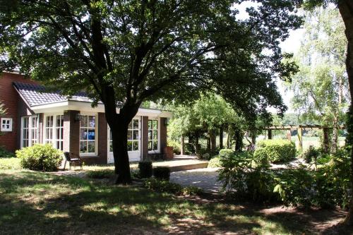 dom z drzewem w ogrodzie w obiekcie Landhuis de heibloem w mieście Heythuysen