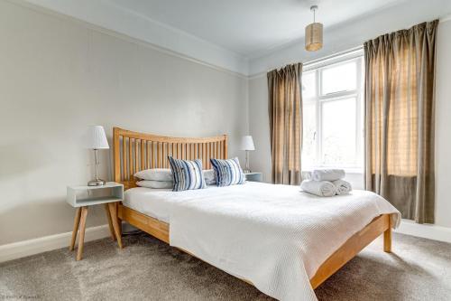 a white bedroom with a large bed with blue pillows at Lavender House in Oxford