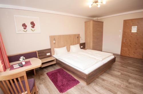 a small bedroom with a bed and a desk at Bed&Breakfast Schwaiger in Mörtschach