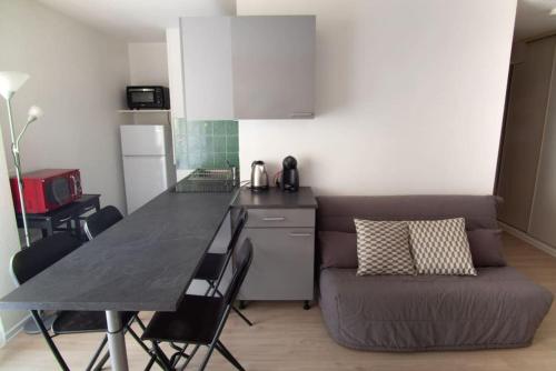 - une cuisine avec un canapé et une table dans une chambre dans l'établissement Nideck - Studio avec balcon, à Strasbourg