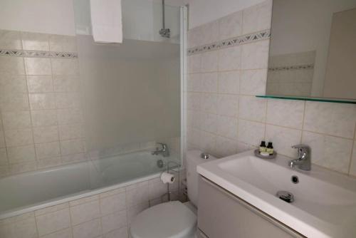 une salle de bain avec toilettes, baignoire et lavabo dans l'établissement Nideck - Studio avec balcon, à Strasbourg