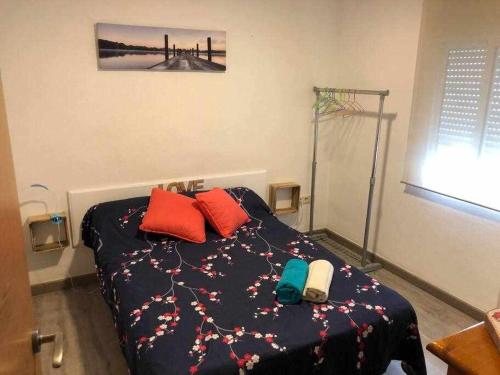 um quarto com uma cama com almofadas coloridas em Amplio con 2 dormitorios y muy equipado LA CANAL em Petrer