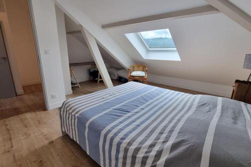 - une chambre mansardée avec un grand lit dans l'établissement Spacieux T3 neuf au calme proche toutes commodités, à Chambéry