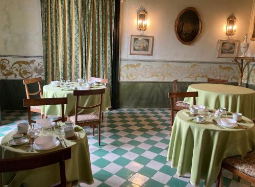 un comedor con 2 mesas con platos y tazas en Palazzo Mazziotti en Celso