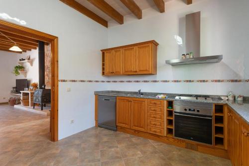 a kitchen with wooden cabinets and a stove top oven at Can Taco in Llucmajor