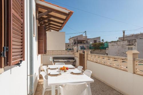 a white table and chairs on a balcony at Vent de Xaloc in Sa Ràpita