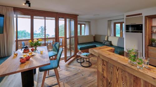 eine Küche und ein Wohnzimmer mit einem Tisch und einem Sofa in der Unterkunft Urlaubsbauernhof Kirchmaier in Chieming