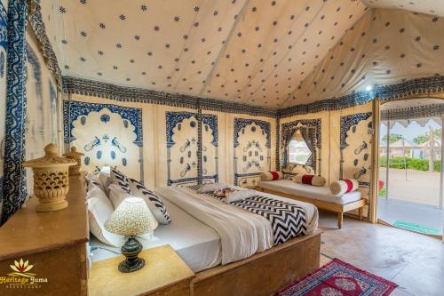 um quarto com uma cama com papel de parede azul e branco em Heritage Juma Resort with swimming pool em Jaisalmer