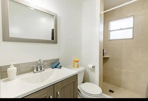 a bathroom with a sink and a toilet and a mirror at One bedroom apt with private patio near Fort Lauderdale beach in Fort Lauderdale