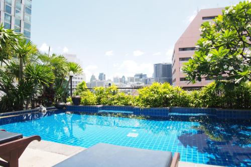 a swimming pool with a city skyline in the background at The Siam Heritage Hotel in Bangkok