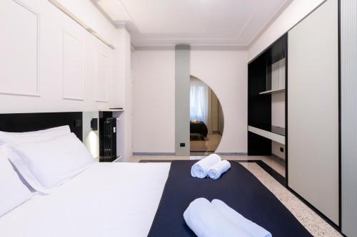 a bedroom with a white bed with two towels on it at LUCIANO LUXURY APARTMENT in Rome
