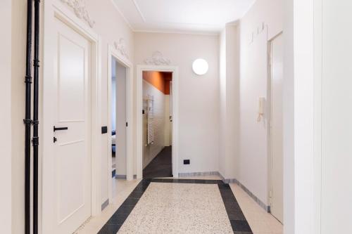 a hallway with white walls and a black and white tile floor at LUCIANO LUXURY APARTMENT in Rome