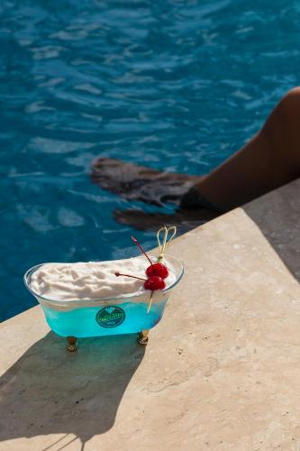 a plastic container with a cherry on it next to a swimming pool at Terra dos Diamantes Hotel in Lençóis
