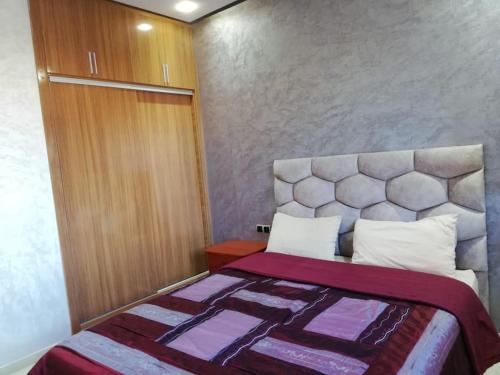 um quarto com uma cama com um edredão roxo em La Perle de L'ocean N03 RDC em Akhfennirr
