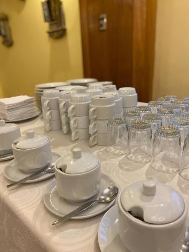 a table with white dishes and glasses on it at Hotel El Puma in Cusco