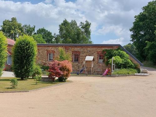 ein Backsteinhaus mit Garten davor in der Unterkunft Ferienwohnung Schöpstalblick in Ebersbach