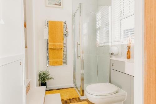 een witte badkamer met een toilet en een douche bij Superb Tiny Home in Caldicot with Parking in Caldicot