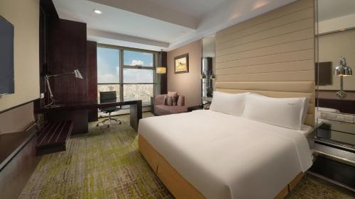 a bedroom with a large white bed and a desk at Holiday Inn Beijing Focus Square by IHG in Beijing