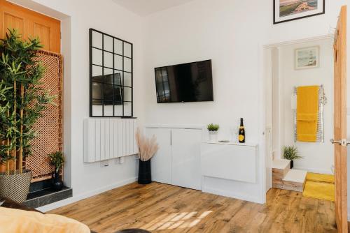 a living room with a tv on a white wall at Superb Tiny Home in Caldicot with Parking in Caldicot