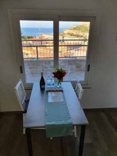 a dining room table with two chairs and a large window at Mare Fuori in Portoferraio