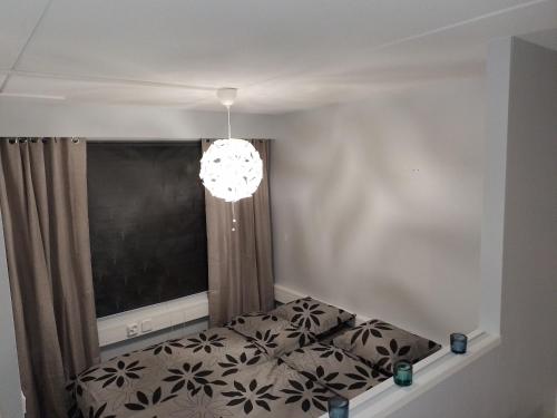 1 dormitorio con cama y lámpara de araña en Huoneisto Ketunpesä, en Taivalkoski