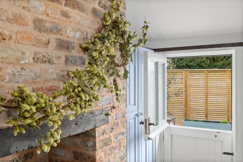 a brick wall with a wreath on a door at The Hop Store in Little Marcle