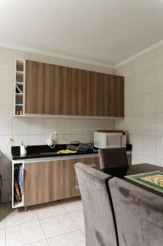 a kitchen with wooden cabinets and a counter top at Casa para 6 pessoas in Bento Gonçalves
