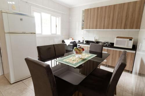y cocina con mesa, sillas y nevera. en Casa para 6 pessoas, en Bento Gonçalves