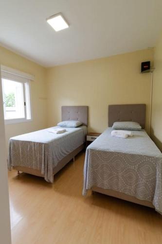 a bedroom with two beds and a window at Casa para 6 pessoas in Bento Gonçalves