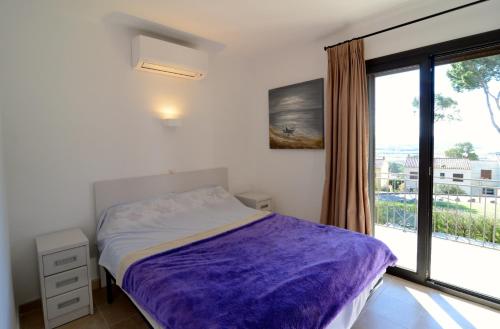 une chambre avec un lit et une grande fenêtre dans l'établissement ATENES 12, à L'Estartit