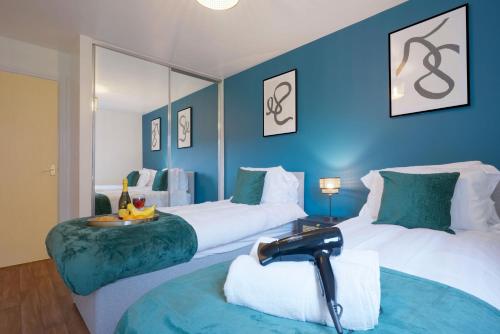 two beds in a room with blue walls at Modern Apartment - Walking Distance to the City Centre - Free Parking, Fast Wi-Fi and Smart TV with Netflix by Yoko Property in Coventry