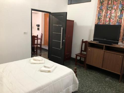 1 dormitorio con 1 cama y TV de pantalla plana en Alojamiento Mitre en Salta