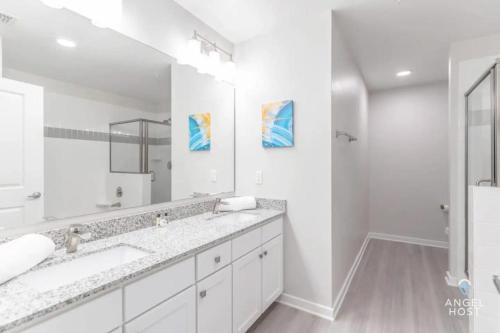 a white bathroom with two sinks and a large mirror at Apartment at Vista Cay Resort in Orlando