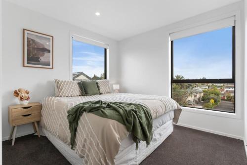 sypialnia z łóżkiem i dużym oknem w obiekcie Contemporary Urban Retreat w Auckland