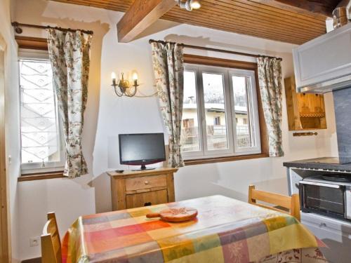 Il comprend une cuisine avec une table et une télévision. dans l'établissement Charmant 2 Pièces avec Jardin Privatif - Proche des Pistes et Navette Gratuite - FR-1-762-22, à Saint-Chaffrey
