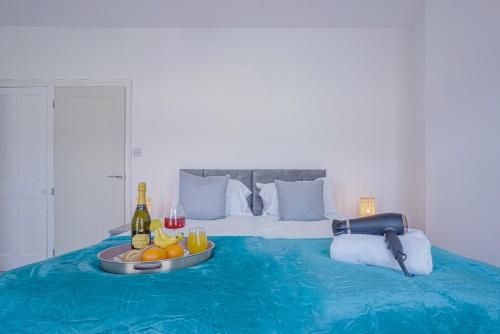 Una cama con una bandeja de fruta y bebidas. en Newly Refurbished House - Close to Town Centre -Free Parking, Super-Fast Wifi, Smart TV with Netflix by Yoko Property, en Northampton