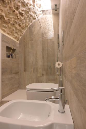 a bathroom with a white sink and a toilet at Pietrabianca Santa Maria Apartments in Manfredonia