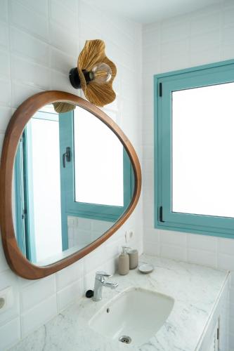 a bathroom with a round mirror and a sink at Vivienda Vacacional Pasito Blanco 1 in Pasito Blanco