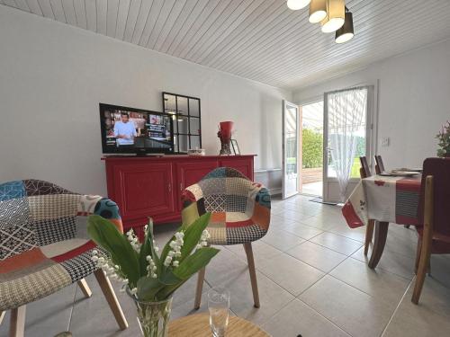 un salon avec une télévision, une table et des chaises dans l'établissement Plein vent, à Soustons