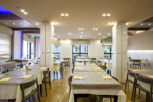 リミニにあるHotel Gardeniaのテーブルと椅子が備わるレストラン