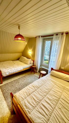 1 dormitorio con 2 camas y ventana en Maison Le Barbier 10pers Le Mont Dore en Le Mont-Dore