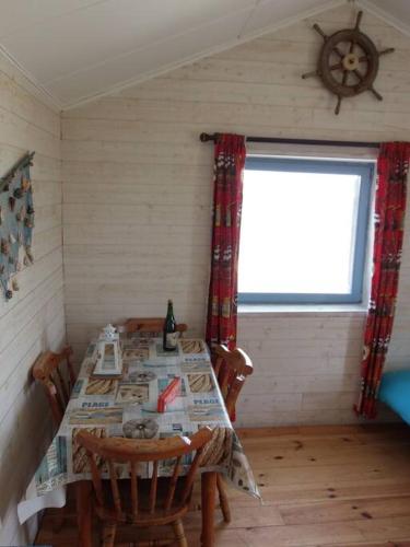 une salle à manger avec une table et une fenêtre dans l'établissement Cabane de douanier en baie du Mont Saint Michel hébergement insolite, à Courtils